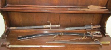 A sword with a curved blade and a metal scabbard together with four bayonets and two spears