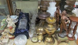 A cased decanter together with drinking glasses, glass vases, resin figures, oil lamps,