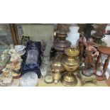 A cased decanter together with drinking glasses, glass vases, resin figures, oil lamps,