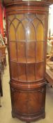 A reproduction mahogany standing corner cupboard with a glazed door of “D” section