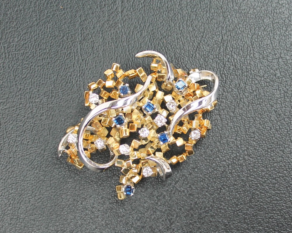 An 18ct yellow and white gold brooch set with nine round brilliant cut diamonds each approximately