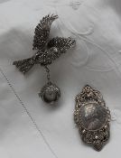 A Marcasite watch in the form of a bird in flight with a ball clock chained to its leg together
