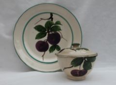 A Llanelly Art Pottery plate, painted with plums on a branch to a green rim border, printed mark,