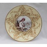 A Mintons porcelain plate, the centre transfer and infil decorated with ice skating cherubs,