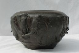 A bronze jardiniere cast with a herd of elephants on a naturalistic base, signed to the underside,