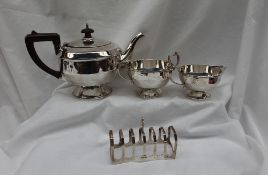 A George V silver three piece pedestal tea set, of stepped tapering form on a spreading foot,