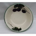 A Llanelly pottery bowl, painted with plums on a branch with leaves, printed mark,