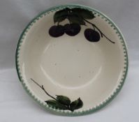 A Llanelly pottery bowl, painted with plums on a branch with leaves, printed mark,