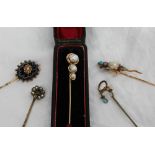 A yellow metal stick pin set with three graduated baroque Pearls, marked 14k,