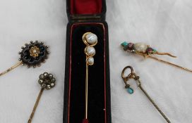 A yellow metal stick pin set with three graduated baroque Pearls, marked 14k,