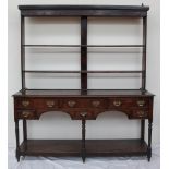 An 18th century South Wales oak dresser, the rack with a moulded cornice above two open shelves,