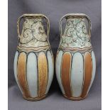 A pair of Royal Doulton stoneware twin handled vases, decorated with flowerheads and green leaves,