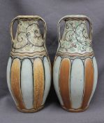 A pair of Royal Doulton stoneware twin handled vases, decorated with flowerheads and green leaves,