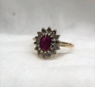 A ruby and diamond cluster ring the central oval faceted ruby surrounded by fourteen diamonds to a