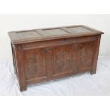 A 17th century oak coffer, the split pin hinged top with three panels,