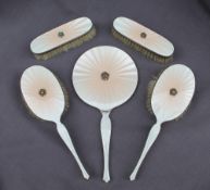 A George V silver and cream enamel part dressing table set, comprising a hand mirror,