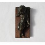 A bronze model of a recumbent cupid, with his head resting on a pillow,