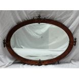 A 20th century copper framed wall mirror of oval form, with flaming vase mouldings,