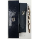 Harry Winston - A 14K yellow gold ball point pen of stylised bamboo design, 13cm long,