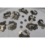 A large collection of white metal coins, including two shillings,