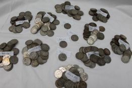 A large collection of white metal coins, including two shillings,