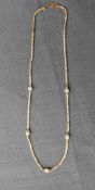 A 22ct yellow and white gold necklace of spiral form with textured balls, 42cm long marked 916,