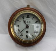 A brass bulk head time piece, the white dial with Roman numerals and a seconds subsidiary dial,