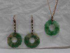 A green and white jade pendant of circular form on a yellow metal chain together with a pair of