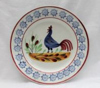 A Llanelly pottery plate, painted with a blue cockerel,