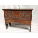 An 18th century oak coffer, the planked top above a leaf and flower carved front on slab ends, 87.