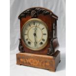 A Victorian walnut cuckoo clock, with an arched top, with leaf carving,