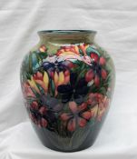 A Moorcroft pottery vase, decorated with spring flowers to a variegated green ground,