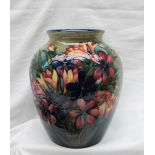 A Moorcroft pottery vase, decorated with spring flowers to a variegated green ground,