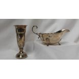 A George V silver sauce boat, with a shaped edge and scrolling handle on leaf capped hoof feet,