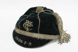 A 19th century sporting cap, in black velvet with white metal braiding and tassel,