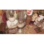 An opaque glass oil lamp together with a collection of oil lamps, flat irons, brass barrel taps,