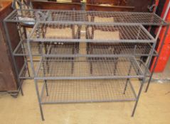 A pair of cast iron and mesh shelves