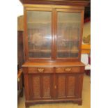 An Edwardian oak bookcase with a moulded cornice above a pair of glazed doors,