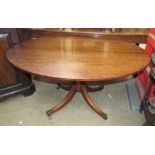 A Regency mahogany supper table with an oval top on a baluster column and four splayed legs