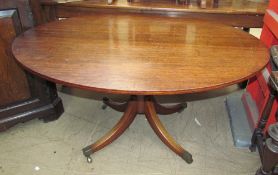 A Regency mahogany supper table with an oval top on a baluster column and four splayed legs