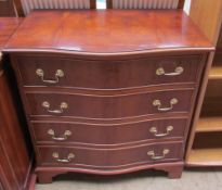 A reproduction yew chest of drawers with a serpentine front