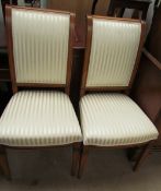 A pair of modern dining chairs with striped cream upholstery