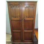 Two oak wardrobes with linen fold panelled doors