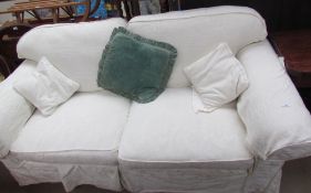 A cream upholstered two seater settee