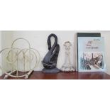A cast iron swan doorstop together with another cast iron door stop, a magazine rack,