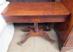 An early Victorian mahogany card table with a rectangular top on a turned column and four legs with