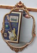 A gilt framed wall mirror together with an oak oval wall mirror