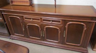 A 20th century mahogany sideboard with a central drawer and four cupboard doors on turned feet,