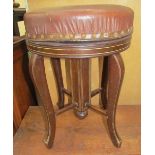 An Edwardian mahogany piano stool with a circular pad upholstered top