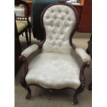 A Victorian walnut library chair, with a carved floral cresting,